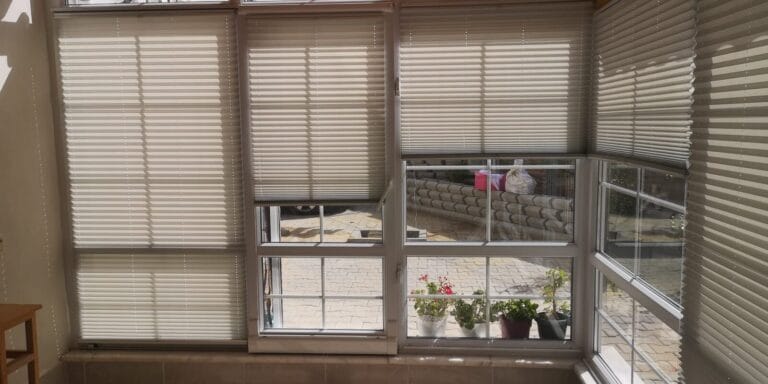 Jaluzi Kapalı balkon camlarında krem plise perdeler